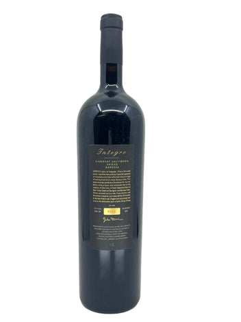 Dark blue wine bottle with a label on a light gray background